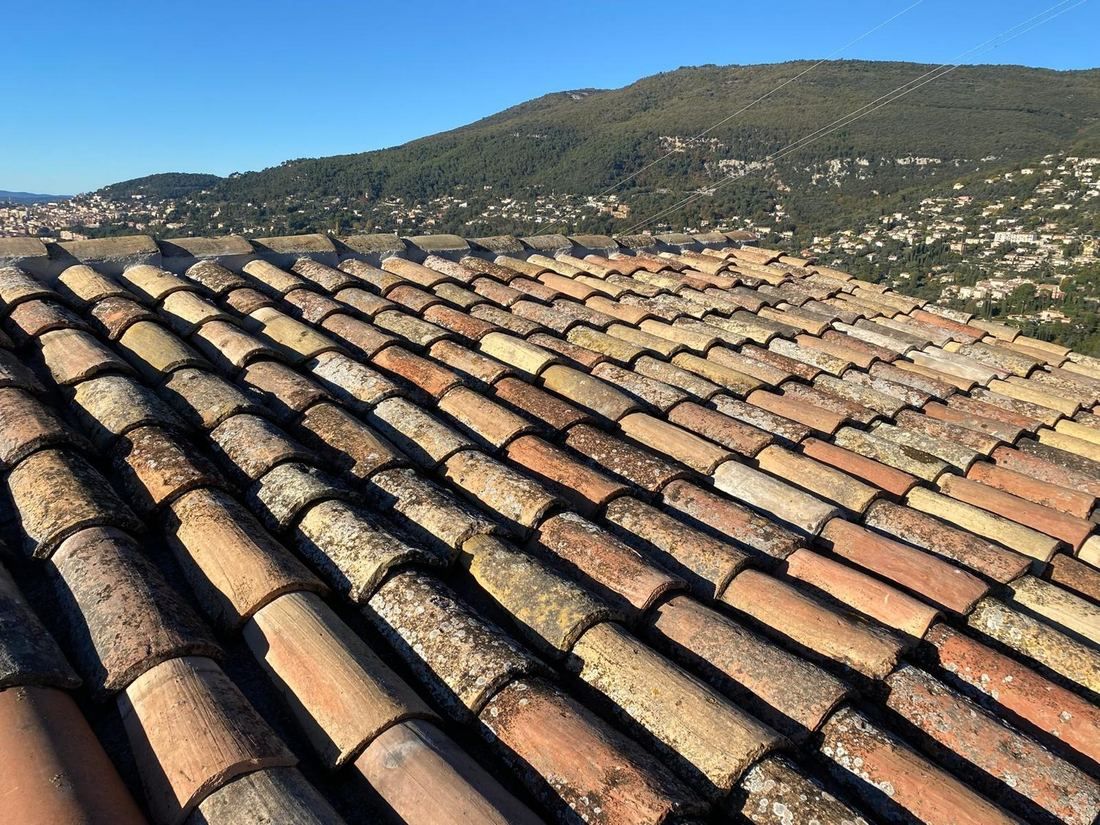Toiture en tuiles rénovée face aux montagnes de l’arrière-pays niçois
