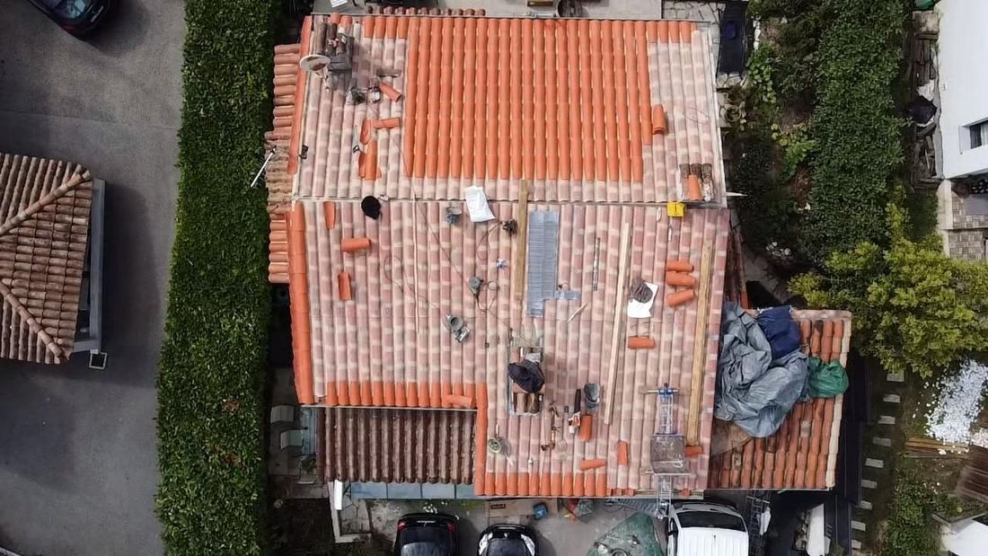 Vue aérienne d’une maison à la toiture en tuiles rénovée
